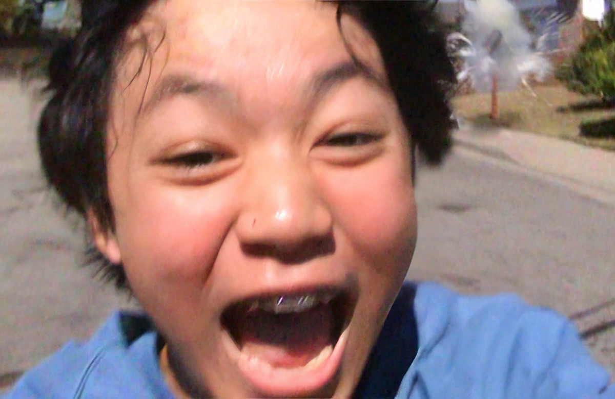 A boy running with a smile on his face.