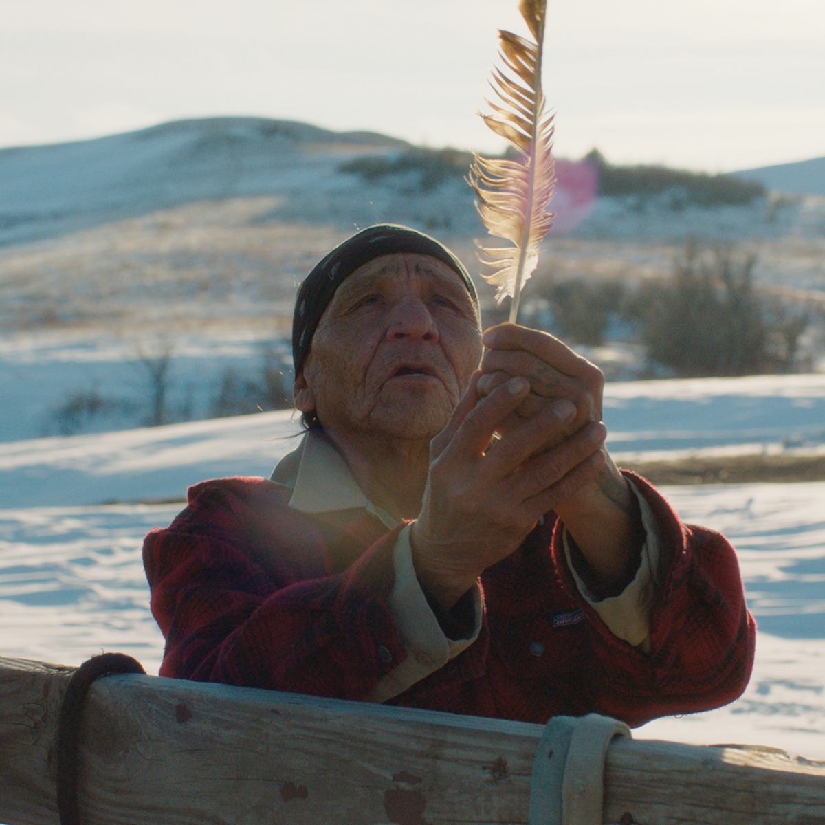 Woman in snow holding feather.