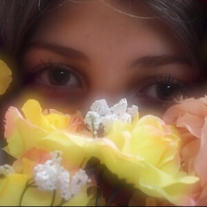 A woman's eyes surrounded by yellow and white flowers.