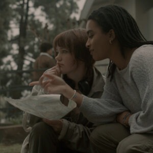 Two girls sitting outside looking at a map.