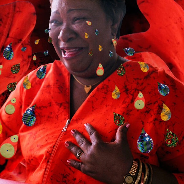 A woman in a red shirt crying colorful tears.