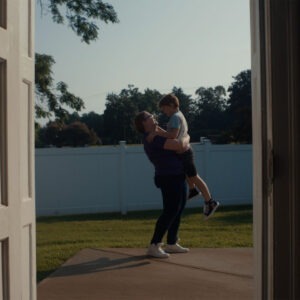 A woman holding a child in a doorway.